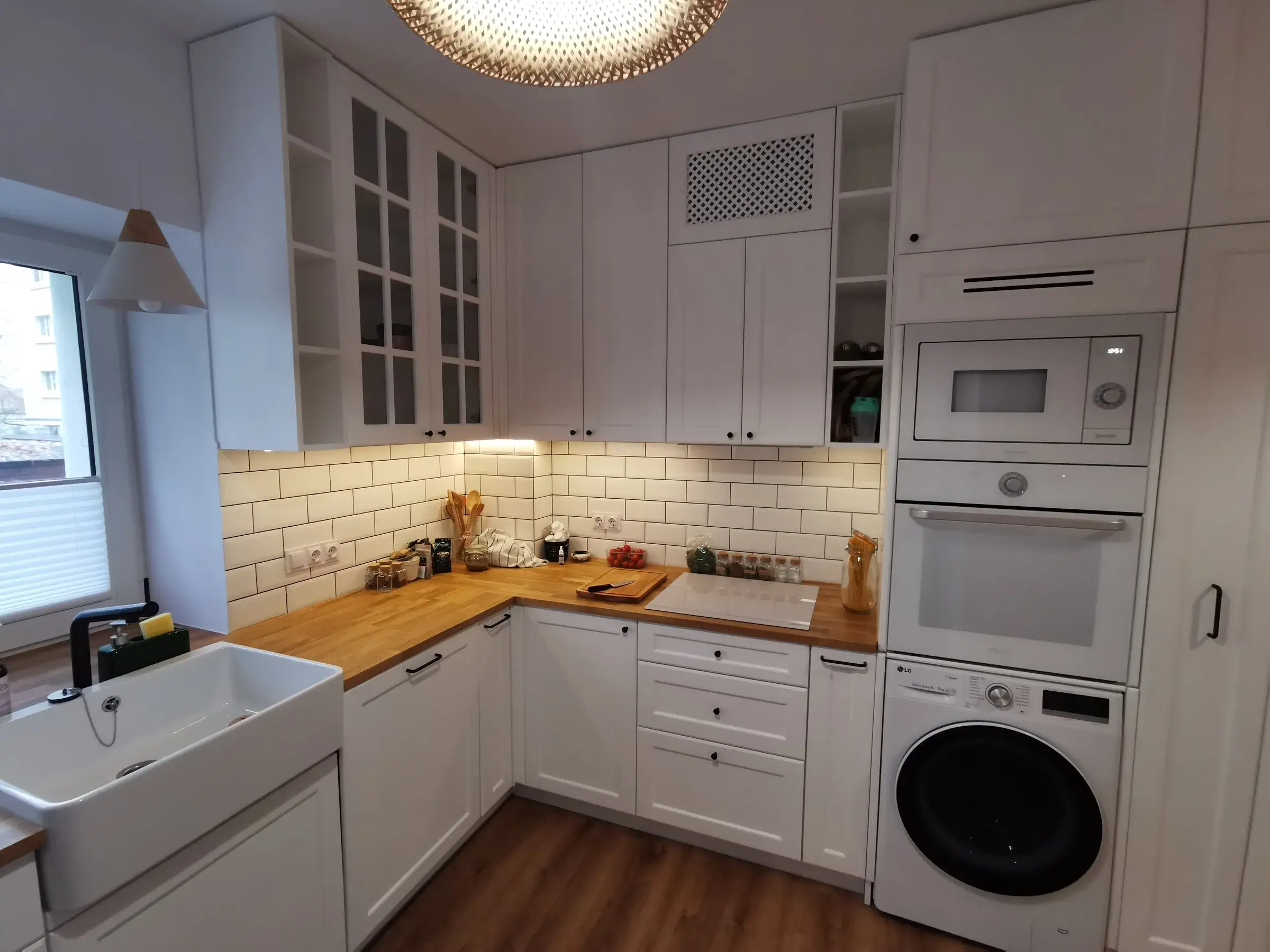 Biała kuchnia ze zlewem ceramicznym i drewnianym blatem